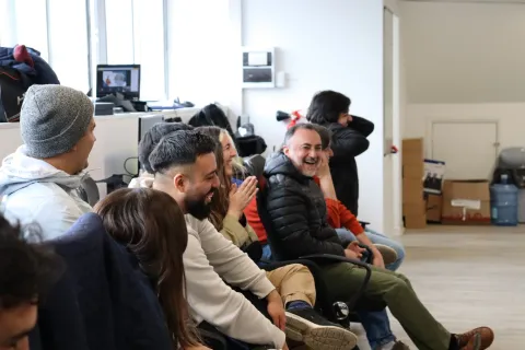 The Yoy team sitting in a room, smiling and laughing together in an office setting.