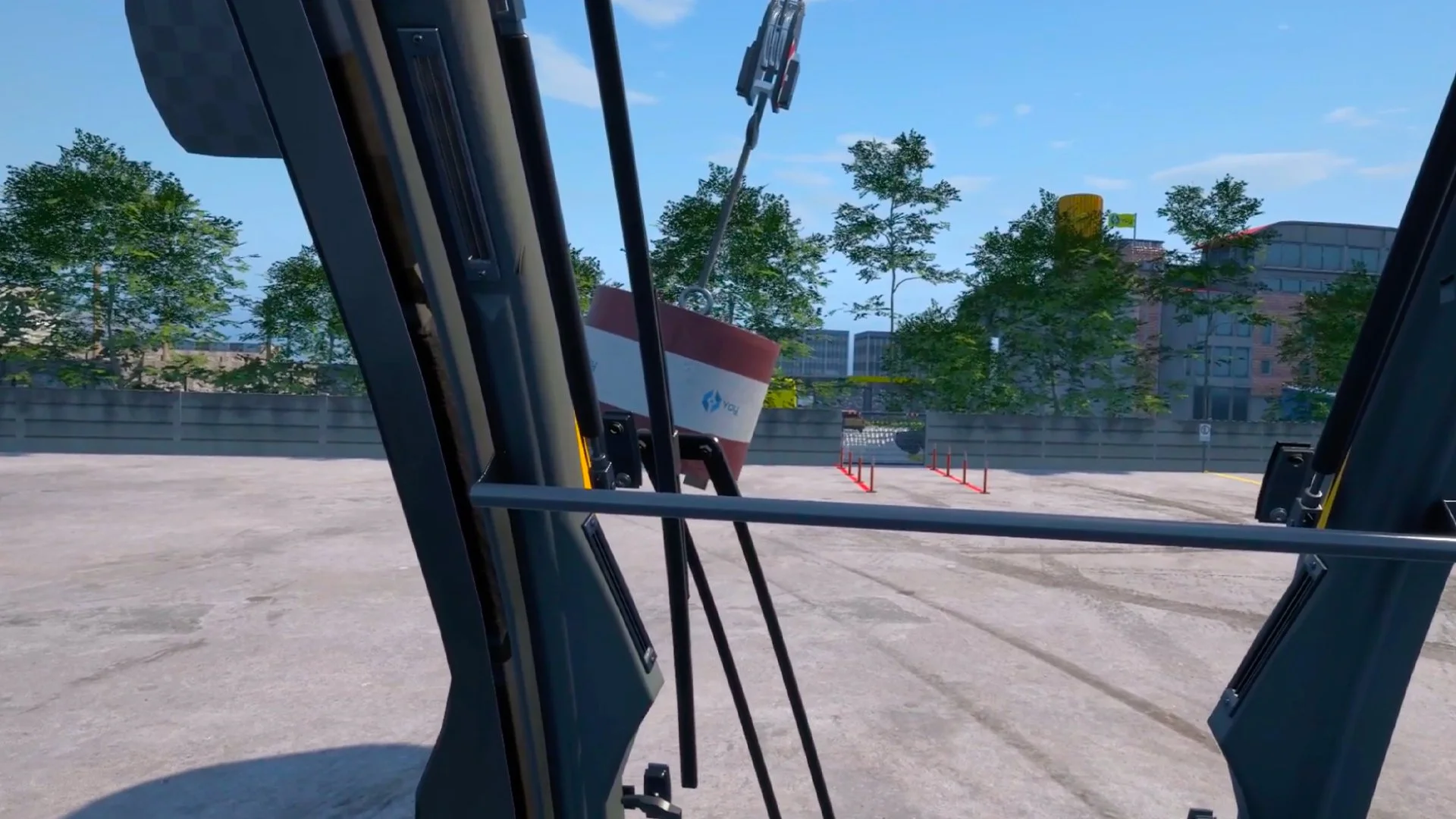 Interior view from inside a vehicle with large windows, a concrete area surrounded by trees and buildings, and a piece of construction equipment outside.