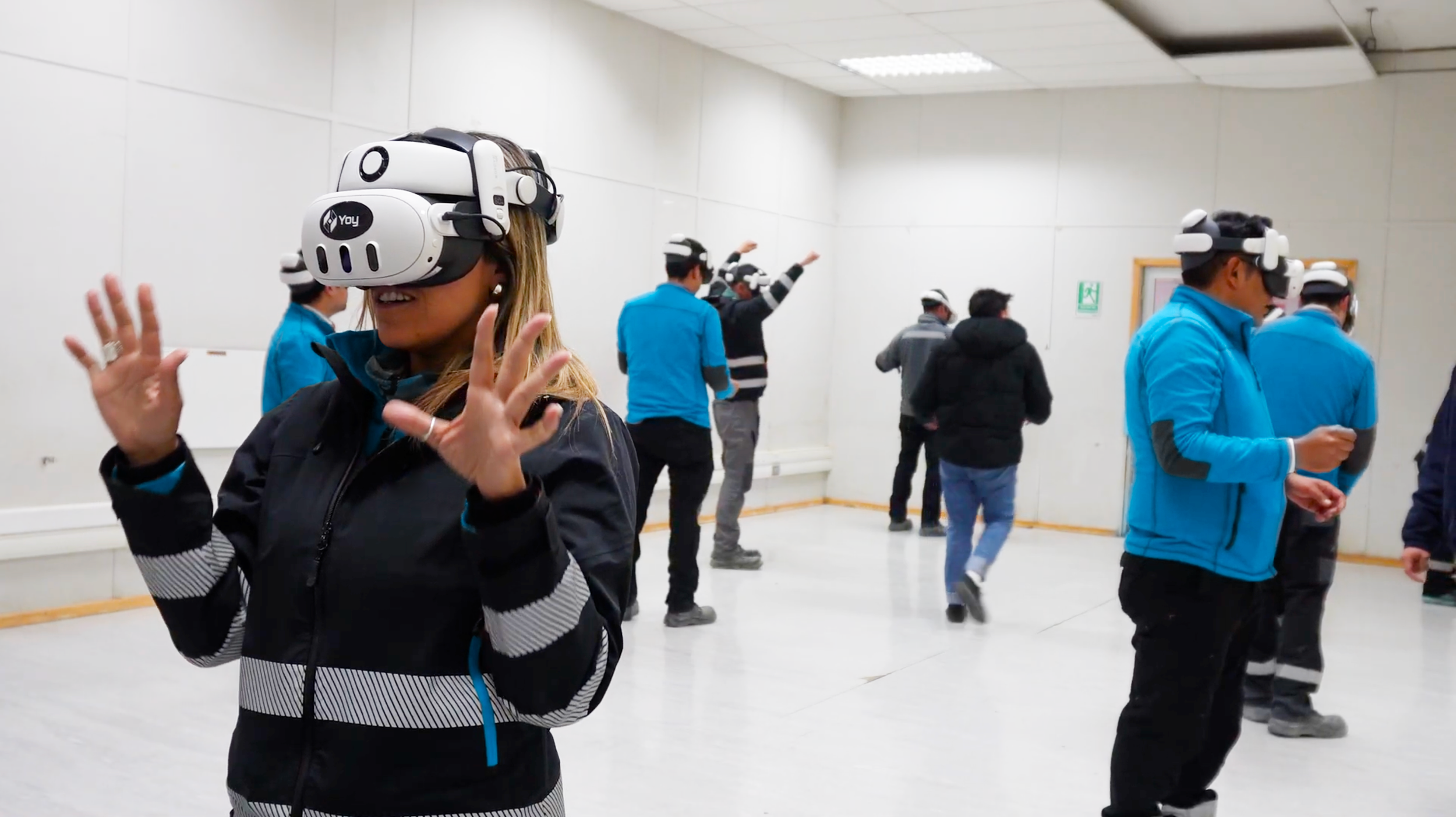 People in a room wearing virtual reality headsets and interacting with a virtual environment.