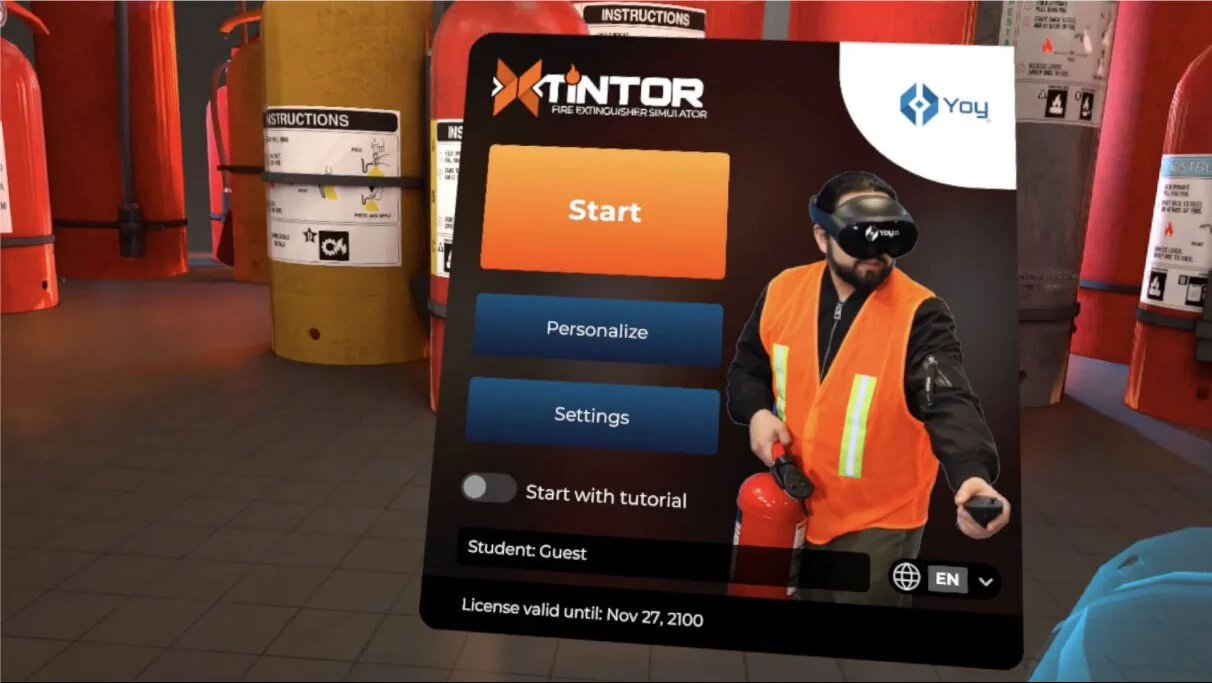 Virtual reality fire extinguisher simulator interface with start button, settings, and a person wearing a VR headset and an orange safety vest holding a fire extinguisher.