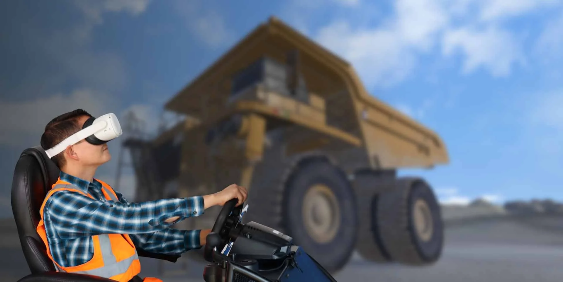 Person wearing a virtual reality headset sitting in a simulated vehicle with a construction truck in the background.